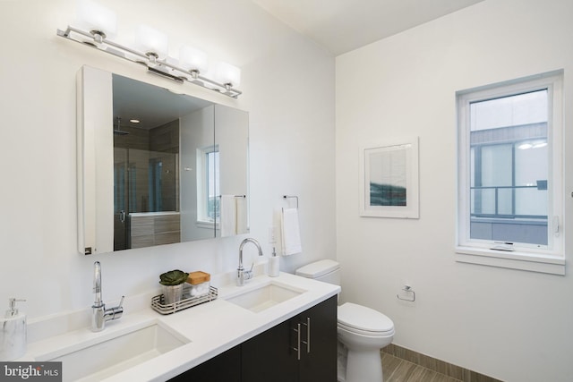 bathroom featuring vanity, toilet, and an enclosed shower