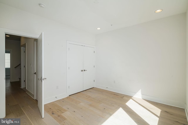 unfurnished bedroom featuring light hardwood / wood-style flooring and a closet