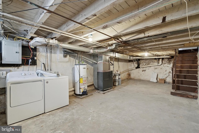 basement featuring washing machine and clothes dryer, electric panel, heating unit, and water heater