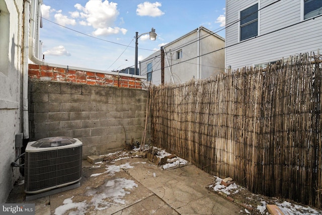 snow covered patio featuring cooling unit