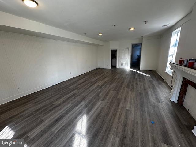 unfurnished living room featuring dark wood-type flooring