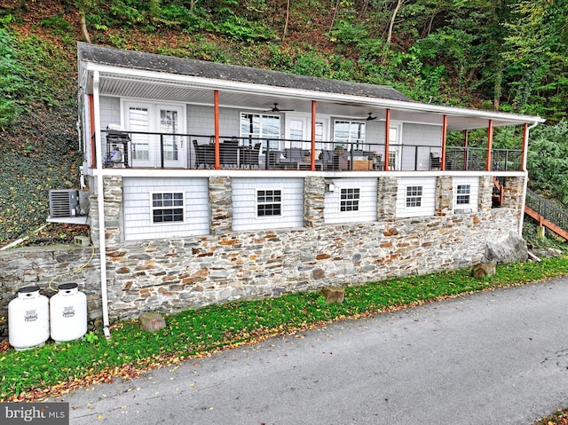 view of side of property with central air condition unit, ceiling fan, and covered porch