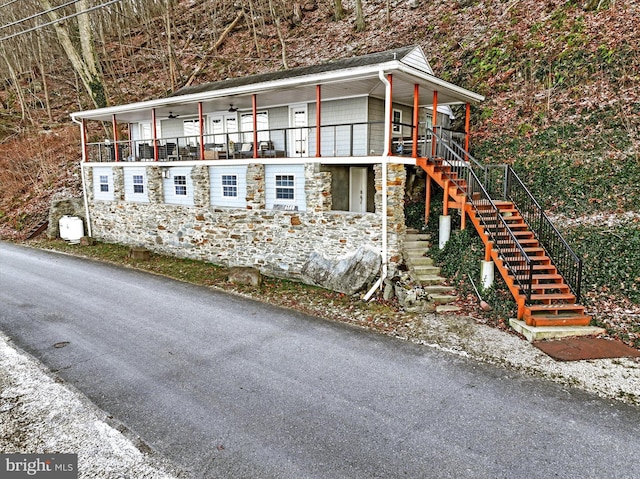 view of side of property with ceiling fan and a porch