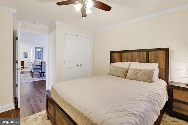 bedroom with dark hardwood / wood-style floors, a closet, crown molding, and ceiling fan