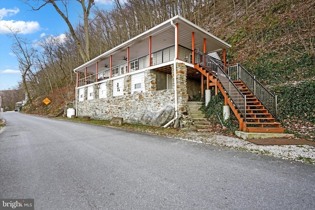 view of side of property with ceiling fan and a porch