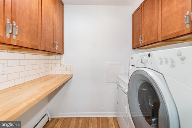 939 Starbit Rd, Towson, MD 21286 - laundry area featuring cabinet space, baseboards, a baseboard heating unit, light wood finished floors, and washer / dryer