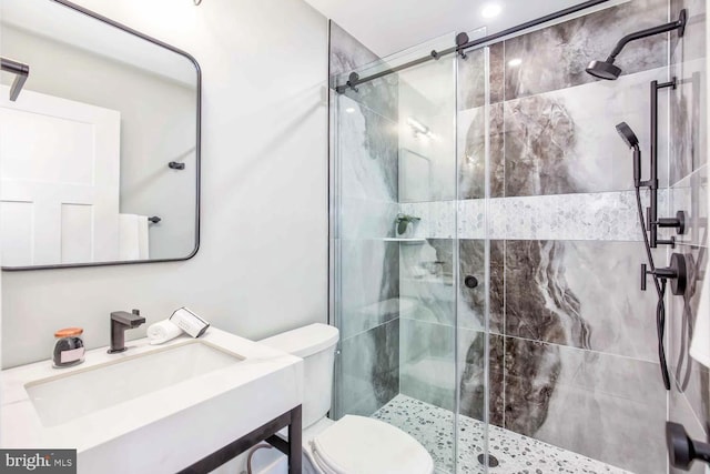 bathroom featuring toilet, vanity, and a shower with shower door