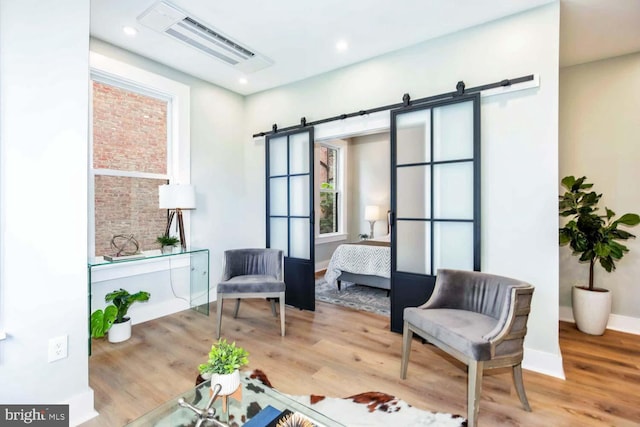 living area featuring hardwood / wood-style flooring and a barn door