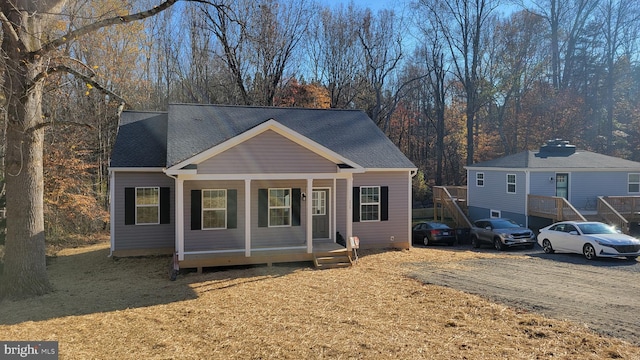 view of front of property featuring a porch and roof with shingles