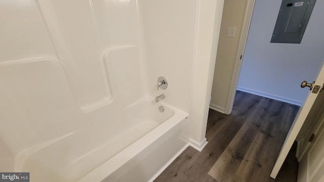 bathroom featuring hardwood / wood-style flooring, bathing tub / shower combination, and electric panel