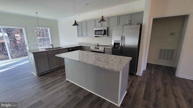 kitchen featuring pendant lighting, visible vents, appliances with stainless steel finishes, a sink, and a peninsula