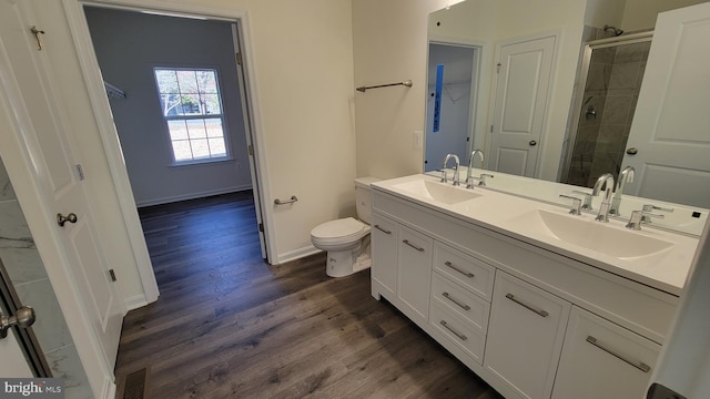 bathroom with hardwood / wood-style flooring, vanity, walk in shower, and toilet