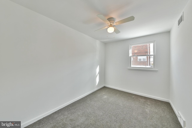 empty room with a ceiling fan, carpet flooring, visible vents, and baseboards