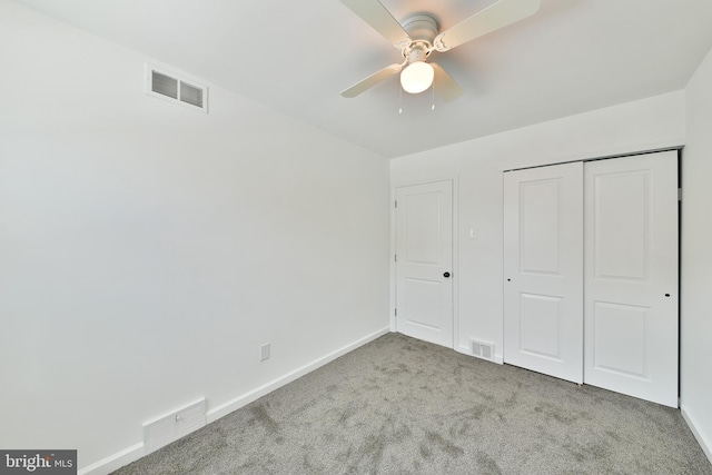 unfurnished bedroom with carpet, visible vents, and baseboards