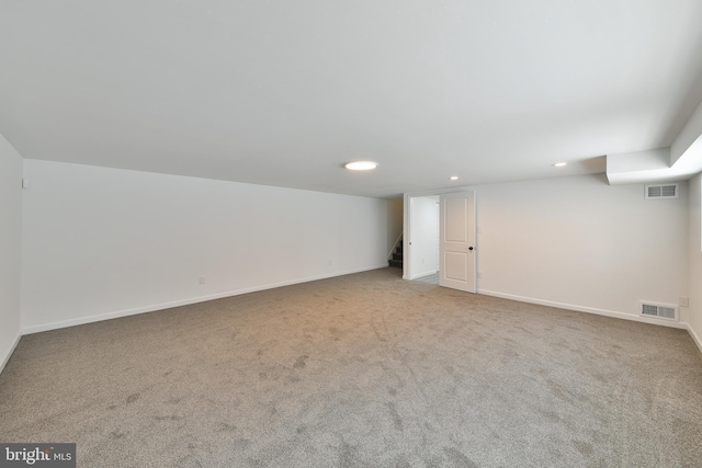 finished basement featuring carpet, visible vents, baseboards, and stairs