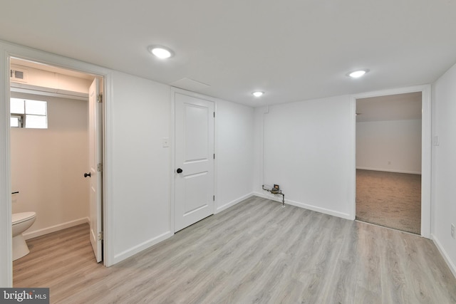 basement with light wood-style floors, baseboards, and visible vents