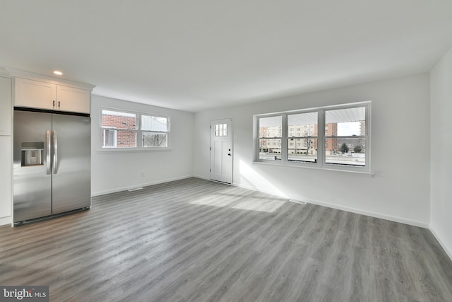 unfurnished living room featuring light wood-style floors, baseboards, and recessed lighting