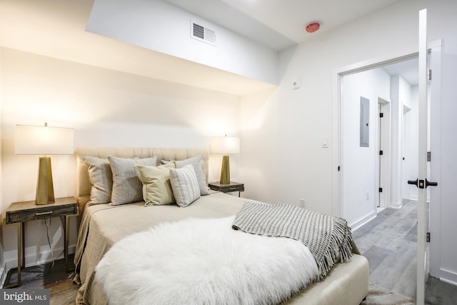 bedroom featuring electric panel and dark hardwood / wood-style flooring