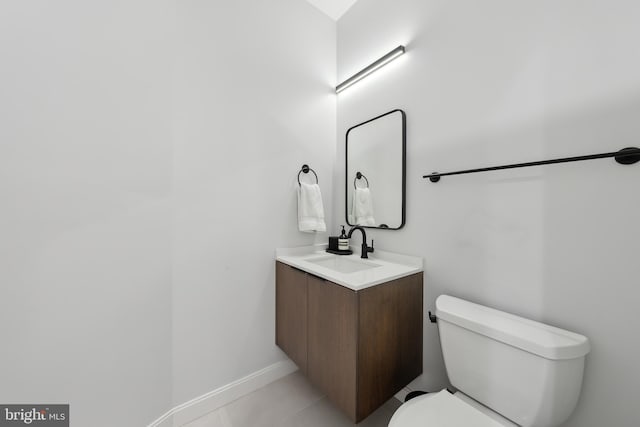 bathroom featuring baseboards, vanity, and toilet