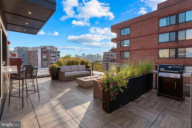 view of patio featuring a view of city, an outdoor living space with a fire pit, and area for grilling