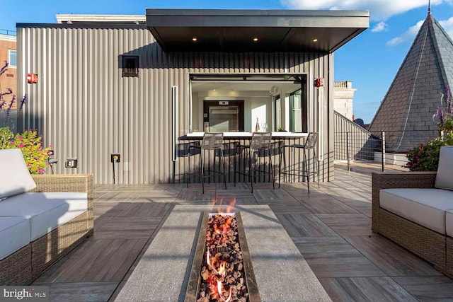 back of property with outdoor lounge area, board and batten siding, and outdoor dining space