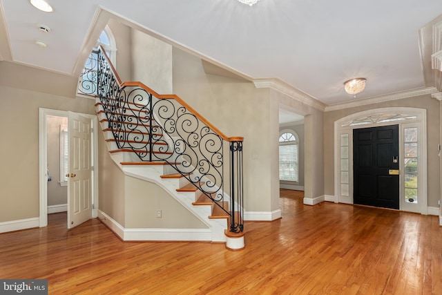 entryway with hardwood / wood-style flooring, ornamental molding, and plenty of natural light