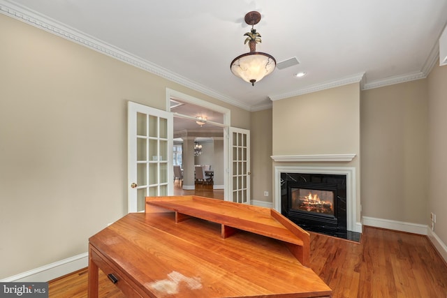 dining area featuring hardwood / wood-style floors, crown molding, and french doors