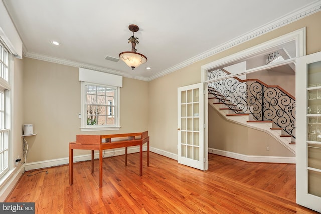 home office featuring hardwood / wood-style floors, a wealth of natural light, ornamental molding, and french doors