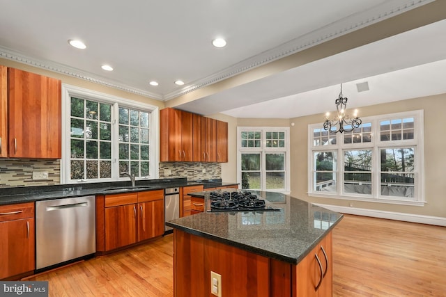 kitchen featuring sink, stainless steel dishwasher, a kitchen island, black gas cooktop, and decorative backsplash