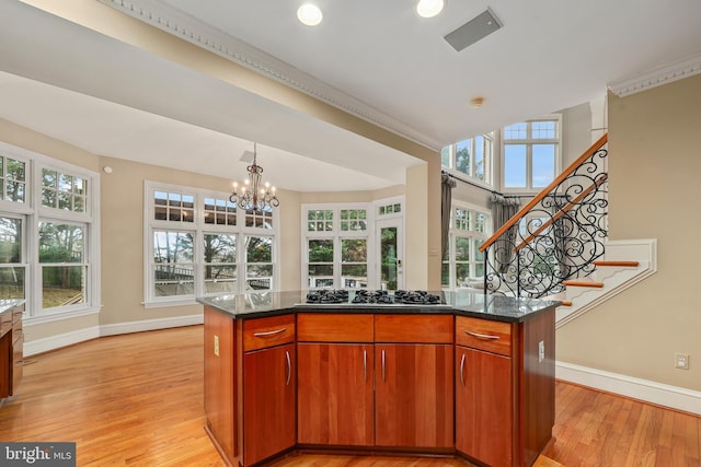 kitchen with plenty of natural light, a center island, stainless steel gas cooktop, and light hardwood / wood-style flooring