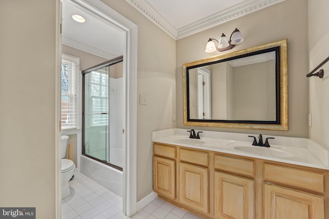 full bathroom featuring tile patterned floors, toilet, crown molding, bath / shower combo with glass door, and vanity