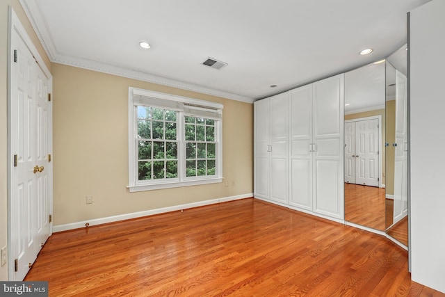 unfurnished bedroom with crown molding and light hardwood / wood-style flooring