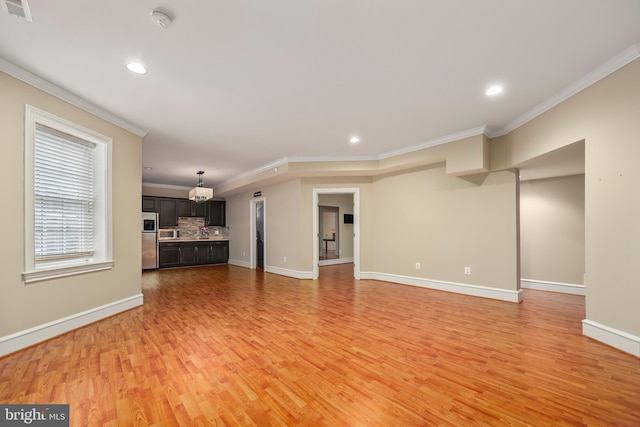 unfurnished living room featuring crown molding and light hardwood / wood-style flooring