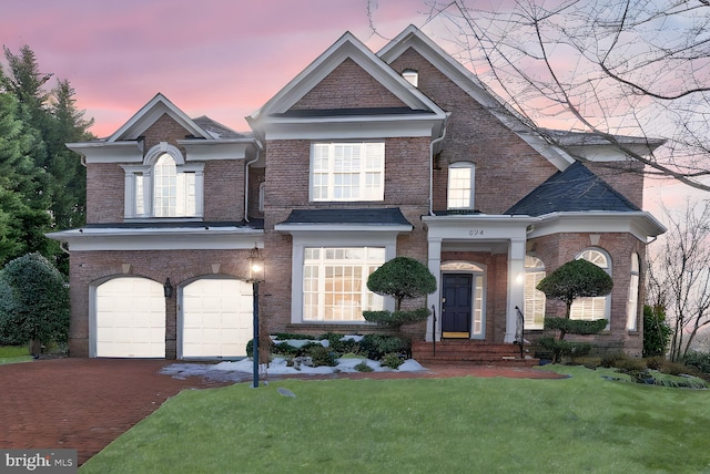 view of front of property with a garage and a lawn