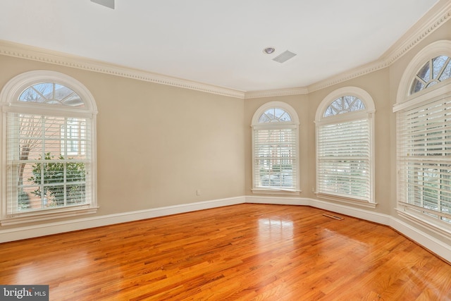 unfurnished room with crown molding, a healthy amount of sunlight, and light hardwood / wood-style flooring