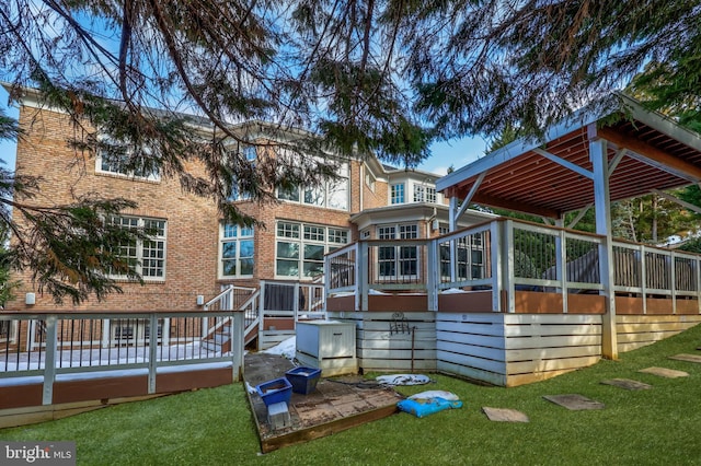 back of property with a sunroom, a yard, and a deck