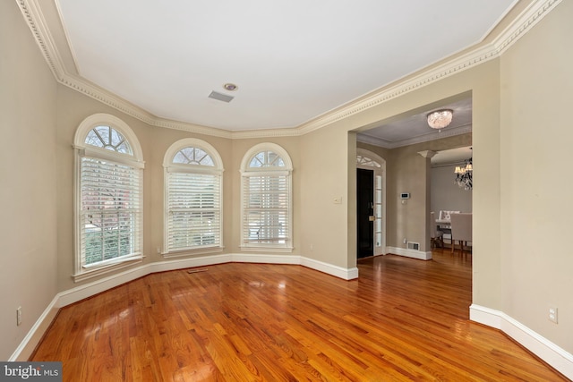 unfurnished dining area with crown molding, hardwood / wood-style flooring, and a chandelier