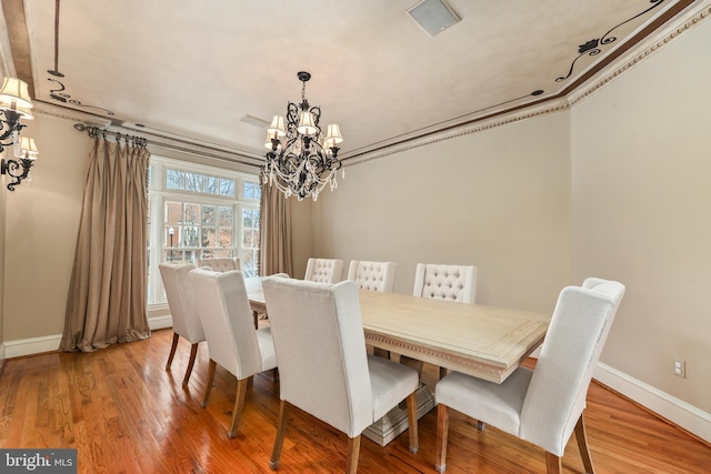 dining area featuring a notable chandelier and hardwood / wood-style flooring