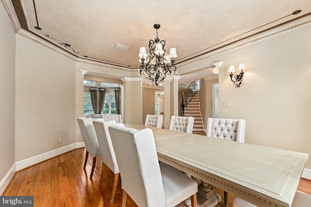 dining area featuring a notable chandelier, crown molding, and wood-type flooring