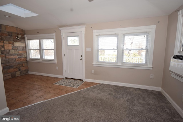 tiled foyer with lofted ceiling with skylight