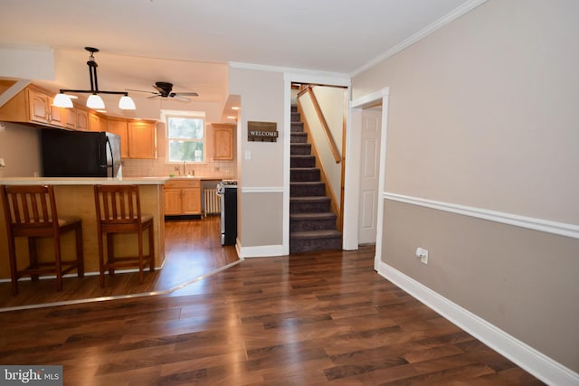 kitchen with black refrigerator, decorative backsplash, dark hardwood / wood-style flooring, and kitchen peninsula