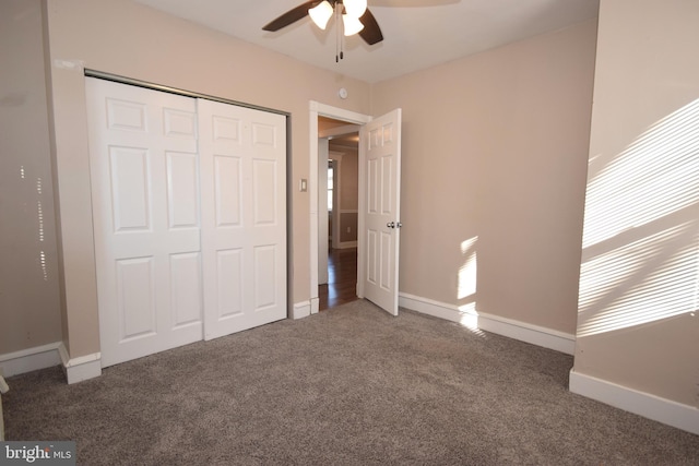 unfurnished bedroom featuring a closet, dark carpet, and ceiling fan