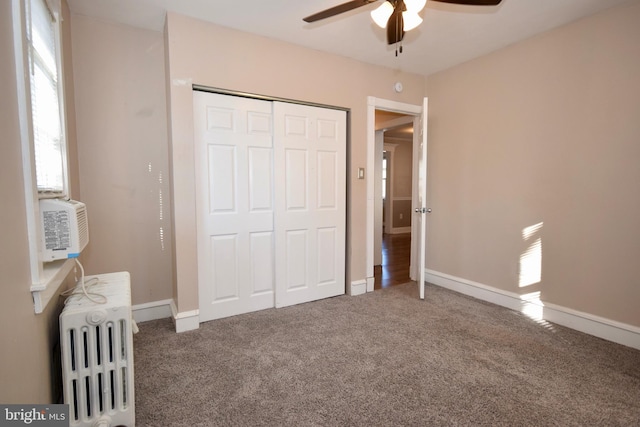 unfurnished bedroom featuring carpet flooring, radiator, ceiling fan, and a closet