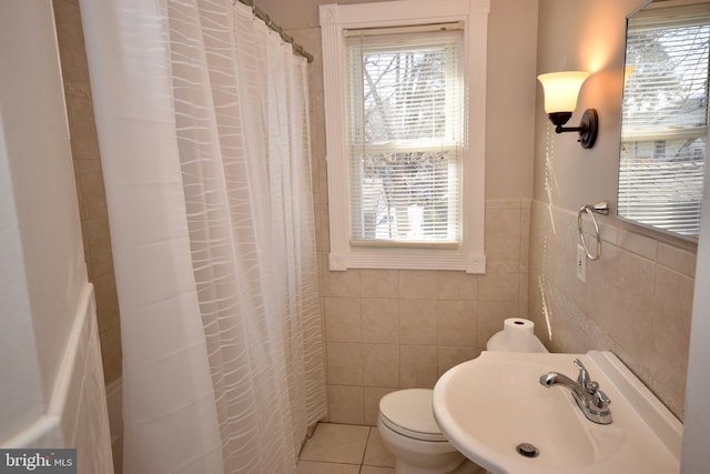 bathroom featuring tile patterned floors, a wealth of natural light, sink, and tile walls