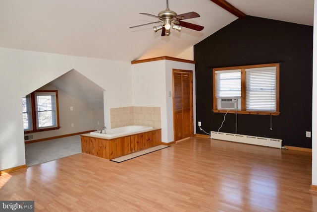 interior space featuring lofted ceiling with beams, ceiling fan, a baseboard radiator, and light hardwood / wood-style floors