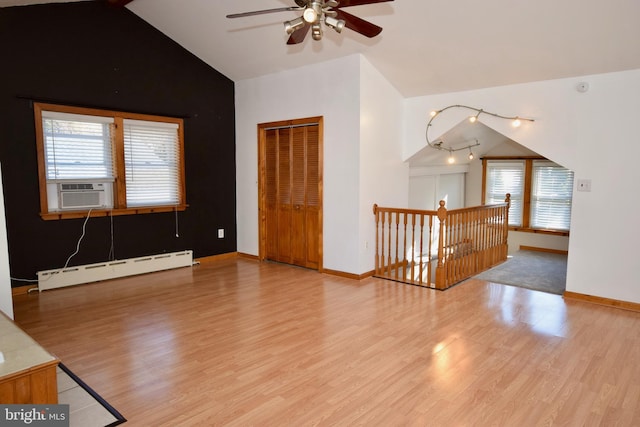 empty room with ceiling fan, baseboard heating, cooling unit, light hardwood / wood-style floors, and vaulted ceiling