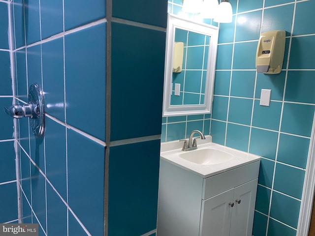 bathroom featuring vanity and tile walls