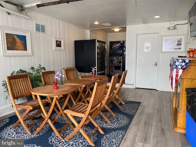 dining space featuring wood walls and wood-type flooring