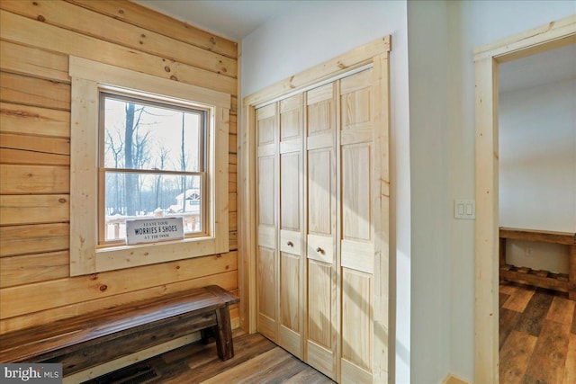 mudroom with wood-type flooring and wood walls