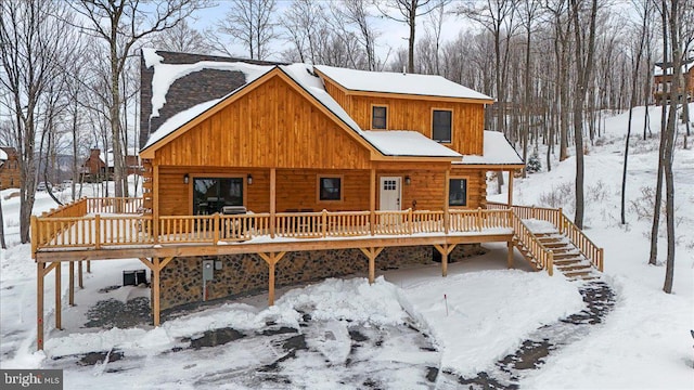 snow covered house with a wooden deck